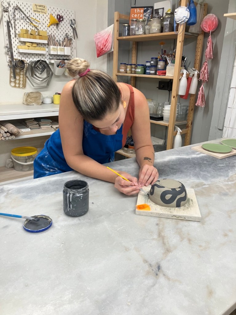 Woman painting a pottery bowl